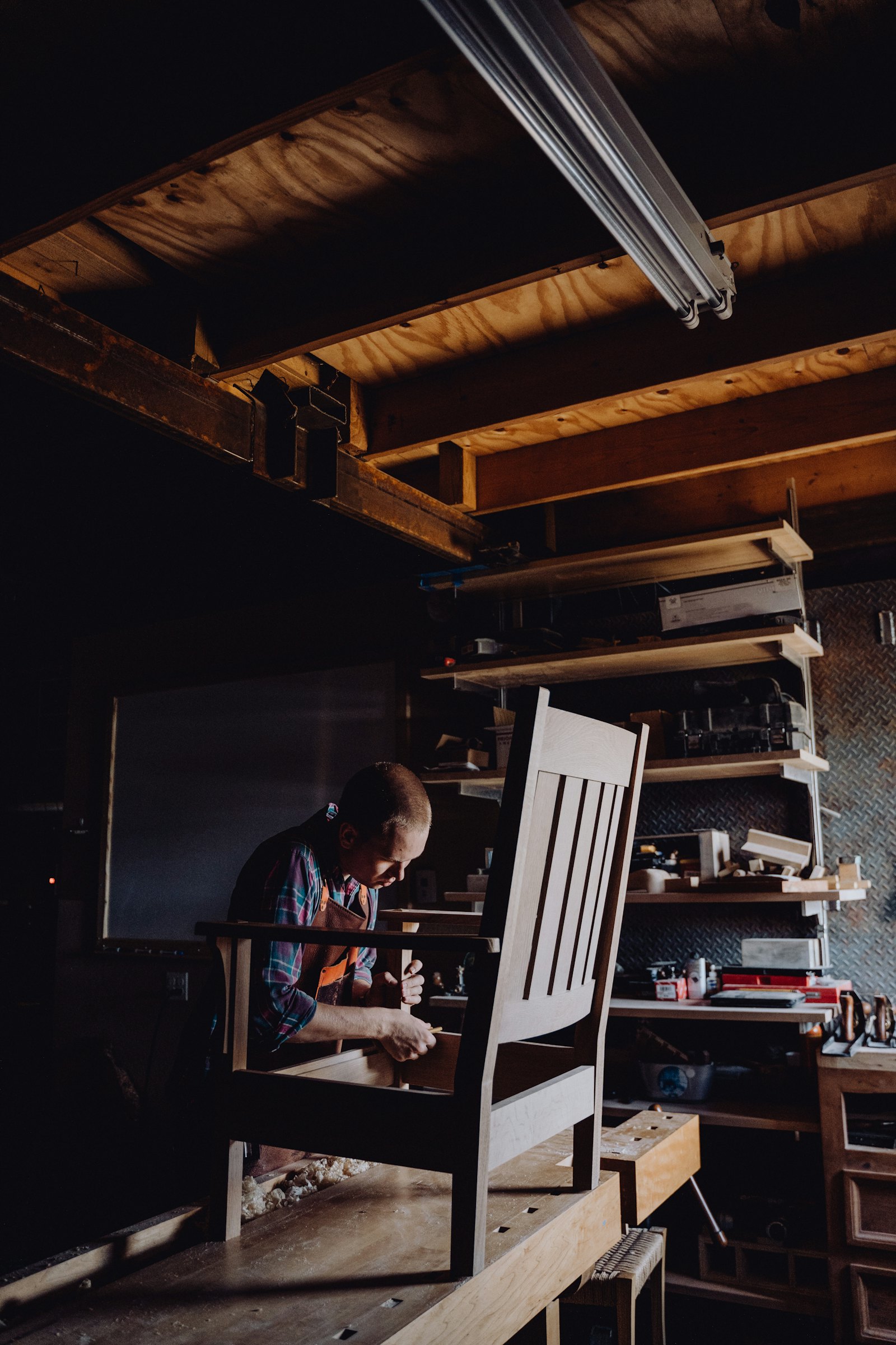 A cabinetmaker shaping wood at the bench in the Kaufman's Kabinets shop